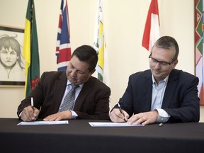 Guy Lonechild, left, CEO First Nations Power Authority (FNPA) and SaskPower CEO Mike Marsh sign an opportunity agreement with SaskPower for 20 megawatts (MW) of new utility-scale solar generation projects.