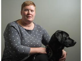Ashley Nemeth kneels next to her new guide dog, Danson, at the CNIB office on Broad Street in November 2018.