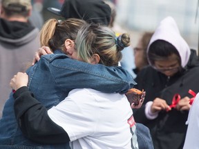 Jackie Wapemoose hugs another woman a gathering to form search parties for her sister Jenaya Wapemoose, a 22-year-old woman who has been missing since March 10th. Beginning at the Esso station on Albert Street and 7th Avenue groups fanned out to put up posters and information.