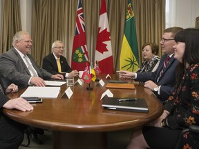 Ontario Premier Doug Ford, left, is joined by Ontario Finance Minister Vic Fedeli as they meet with Saskatchewan Premier Scott Moe, second right, Saskatchewan Finance Minister Donna Harpauer, third right, and Chief of Staff Shannon Andrews, right, in Toronto, on Friday, May 10, 2019.