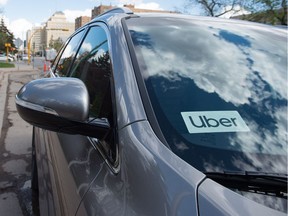 An Uber vehicle sits in front of Regina City Hall during an event to mark the ride-sharing company's launch in the city.