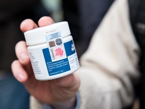 FILE - A customer shows a marijuana product that he bought after entering a cannabis store on October 17, 2018 in Montreal, Quebec.