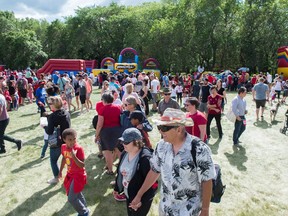 Visitors wander while parents and children wait in line for children's activities on the north side of Wascana Lake during Canada Day festivities on July 1, 2018.