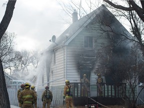 Firefighters work at a house fire on the 1100 block of Cameron Street. The fire was later determined to be an arson.