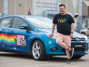 Dan Shier, co-chair of Queen City Pride, stands near a Pride-themed car in the parking lot of the Centennial Market at the corner of Hamilton Street and 6th Avenue. The Pride parade will now be staging in this area after a route change in order to avoid construction on Victoria Ave.