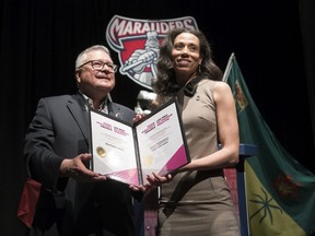 Minister of Public Safety and Emergency Preparedness Ralph Goodale, left, presents Miller Comprehensive Catholic High School teacher Heather Faris, who teaches science, health science and biology, with the Prime Minister's Award for Teaching Excellence in STEM Certificate of Achievement in Regina.