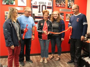 A ribbon-cutting is held for the Adam Herold Memorial Room on Saturday at the Co-operators Centre. Shown in the middle are Adam's father Russ (blue shirt), Adam's mother Raelene (cutting ribbon) and Adam's sister Erin (dark jacket).  Also shown are Andrea Closs (far left) and Dan Closs (far right), who billeted Adam when he played for the Pat Canadians.