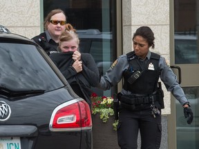 Former Regina businesswoman Alena Marie Pastuch, centre, leaves Regina's Court of Queen's Bench in custody after being found guilty on charges of theft, fraud and money laundering.