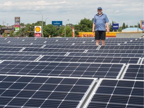 John Brazill, director of large scale solar projects with Wascana Solar Co-operative, stands among solar panels on the roof of the Conexus Credit Union North Albert branch.