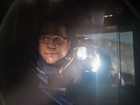 Tom McGill stands next to his Simplex 35mm cinema projector. The projector, which fully assembled weighs about 700 pounds, was shipped to him from Montreal.