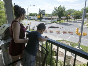 Cassandra Frigon and her 4-year-old nephew Marshall Myran look at large sink hole that appeared at the intersection of Elphinstone Street and Avonhurst Drive. The hole appeared yesterday on Canada Day in Regina.