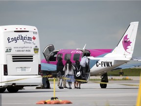 Evacuees from Pikangikum First Nation board a charter flight to return home at the Regina International Airport in Regina on Wednesday.