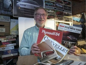 Dale Johnson, Leader-Post's automotive journalist, holds up old brochures he's saved up over decades at his home in Regina.