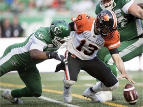 Saskatchewan Roughriders defensive end Charleston Hughes, left, created havoc for the B.C. Lions and quarterback Mike Reilly, 13, on July 20 at Mosaic Stadium.