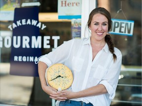 Aleana Young, owner of Takeaway Gourmet, holds a wheel of Shropshire cheese in front of the business on Robinson Street. Cheese is among the food products her business carries. Young is one of several local businesses that pay their employees $15 per hour.