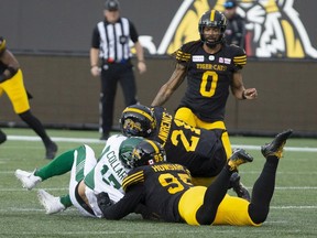 Saskatchewan Roughriders quarterback Zach Collaros is hit late by Hamilton Tiger-Cats' Simoni Lawrence after Collaros was downed by Tiger-Cats' Julian Howsare during first half CFL game action in Hamilton on June 13. Collaros left the game and was soon placed on the six-game injured list.