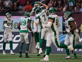 Saskatchewan Roughriders receiver Kyran Moore, back centre, and quarterback Cody Fajardo, 7, celebrate Moore's touchdown during Saturday's 45-18 CFL victory over the host B.C. Lions.