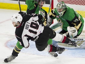 Prince Albert Raiders goalie Ian Scott watches teammate #8 Brayden Pachal clear Vancouver Giants #19 Dawson Holt from in front of the net in Game 4 of the WHL championship series playoffs at the Langley Event Centre.