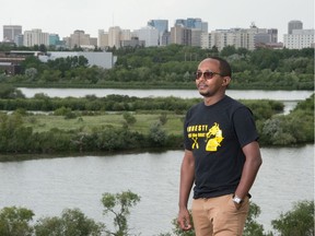 Journalist Mastewal Birhanu stands on a hill in Douglas Park with Regina's cityscape behind him. Birhanu worked for an Ethiopian newspaper focusing on exposing human rights issues and government corruption, but now lives in Regina.