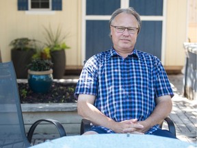 Bob Hilderman, who was bitten by a bat in the basement of his Regina home, sits in his back yard.