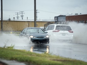 REGINA, SASK :  August 12, 2019  --  Vehicles spray water from large puddles as they travel down Dewdney Avenue in Regina. TROY FLEECE / Regina Leader-Post