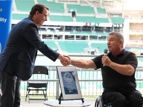 Rick Hansen, founder of the Rick Hansen Foundation, presents Mayor Michael Fougere with an award for Mosaic Stadium achieving the highest accessibility rating of Accessibility Certified Gold.
