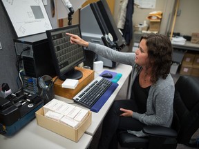 Becky Hahn, special media technician for the Provincial Archives of Saskatchewan, sits in the Archive's digitization area where small town newspapers are being converted into digital files. She is seen here explaining the process of turning microfilm into digital images.