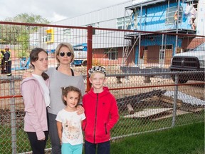 Sarah Cummings Truszkowski and her children, Ella Truszkowski, left, Otis Truszkowski, right, and Grace Truszkowski stand in front of constrcution going on behind École Connaught Community School. Cummings Truszkowski is concerned about overcrowding and portable classrooms reducing playground space.
