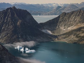 In this photo taken on Wednesday, Aug. 14, 2019, icebergs are photographed from the window of an airplane carrying NASA Scientists as they fly on a mission to track melting ice in eastern Greenland.