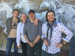 Connie Kaldor and Paul Campagne (centre) with their sons Aleksi Campagne (left) and Gabriel Campagne (right) pose for a photo, in front of a mural by artist Debora Cardaci, at the Campagne family farm near Willow Bunch.