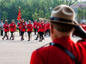 An RCMP officer among the crowd salutes fellow officers during the annual RCMP National Memorial Service at the RCMP academy in Regina, Saskatchewan on Septmber 10, 2017. (Brandon Harder/Regina Leader-Post)