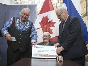 David Chartrand, left, Minister of Veterans Affairs for the Métis National Council and President of the Manitoba Métis Federation, and Lawrence MacAulay, right, federal Minister of Veterans Affairs and Associate Minister of National Defence, present veteran Norman Goodon a cheque for $20,000.