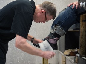 Dale Bowes, owner of the shoeshine shop at the Hotel Saskatchewan, shines the shoes of longtime customer Darcy Vindevoghel. Sock guards can be seen stuffed into Vindevoghel's shoes to ensure no polish finds its way onto his socks.