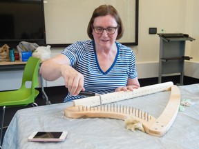 Mardell Blackwood-Wedel takes part in a harp-making workshop held at the University of Regina Conservatory of Performing Arts on College Avenue. She can be seen putting in the pegs, to which the harp's strings will be attached.