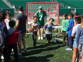 Saskatchewan Roughriders quarterback Cody Fajardo runs some football drills with elementary school students at Mosaic Stadium on Wednesday.
