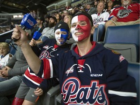 Tyler Broley, right, and his 11-year-old son, Connor, cheer on the Regina Pats during Friday's game against the Moose Jaw Warriors at the Brandt Centre.