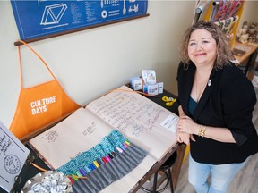 Theresa Kutarna, co-owner of Paper Umbrella on 13th Avenue, stands with the Cathedral Oversized Art Journal, in which visitors have doodled over the years. The journal is on display Friday and Saturday as part of Culture Days.