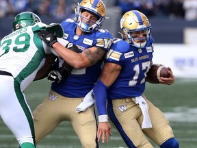 Winnipeg Blue Bombers quarterback Chris Streveler (17) with the ball while Drew Wolitarsky (82) blocks Saskatchewan Roughriders (39) Charleston Hughes during game action during the Banjo Bowl in Winnipeg.