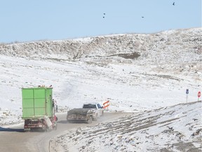 Trucks deliver garbage to the landfill.