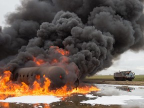 Firefighters from the Regina Airport Authority Fire Department participate in a training scenario at the Regina airport. The department is required by Transport Canada to maintain a response time of under three minutes from dispatch until they reach an aircraft. Drills such as this one, in which gasoline is used to create a controlled fire in a mock aircraft fuselage, help the department maintain its readiness.