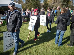 People carry signs while attending the World Teacher's Day festivities in Wascana Park across from the Saskatchewan Legislative Building.