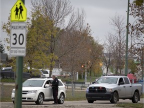 A member of the Regina Police Service issues a ticket in a school zone in Regina.