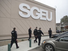 Members of the Regina Police Service exit the SGEU head office after they were called on Thursday during a protest of SGEU president Bob Bymoen.