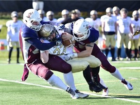 Ryland Gibb, left, and Myles Bistritzan, right of the Regina Thunder tackle Trey Irwin of the Edmonton Huskies during Prairie Football Conference semi-final action at Leibel Field.