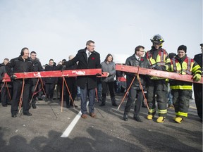 Premier Scott Moe, second from left, helps remove ceremonial barriers from the Regina Bypass a day before it being officially opened to the public in Regina.