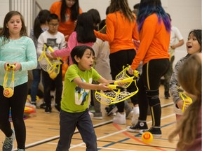 High school students and elementary school students play a game during the Growing Young Movers program being held at the mamaweyatitan centre.