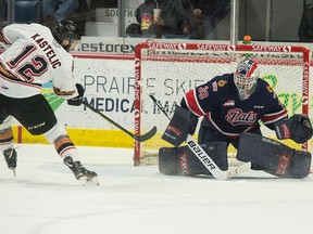 Regina Pats goaltender Max Paddock turns away Calgary Hitmen captain Mark Kastelic during WHL action at the Brandt Centre on Wednesday.