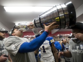 Winnipeg Blue Bombers quarterback Zach Collaros drinks from the Grey Cup on Sunday night at McMahon Stadium in Calgary.