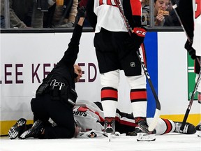 A medical staff member calls for assistance while attending to Senators winger Scott Sabourin on the ice in Boston on Saturday evening.