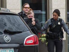 Former Regina businesswoman Alena Marie Pastuch, centre, leaves Regina's Court of Queen's Bench in custody after being found guilty on charges of theft, fraud and money laundering on June 27, 2019.